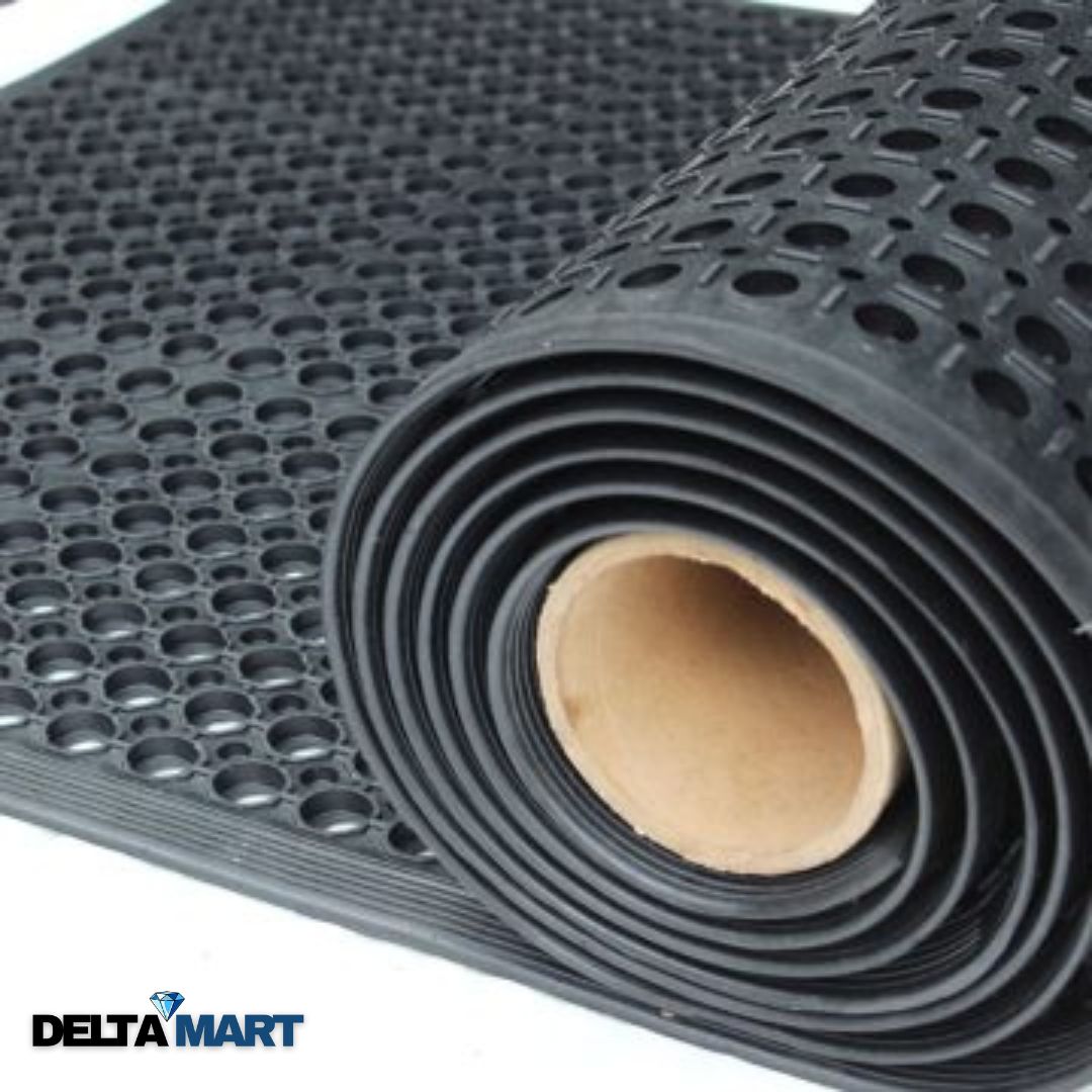 Rolled black perforated rubber mat with circular holes and a visible cardboard core, suited for anti-slip flooring (Delta Mart logo at corner).