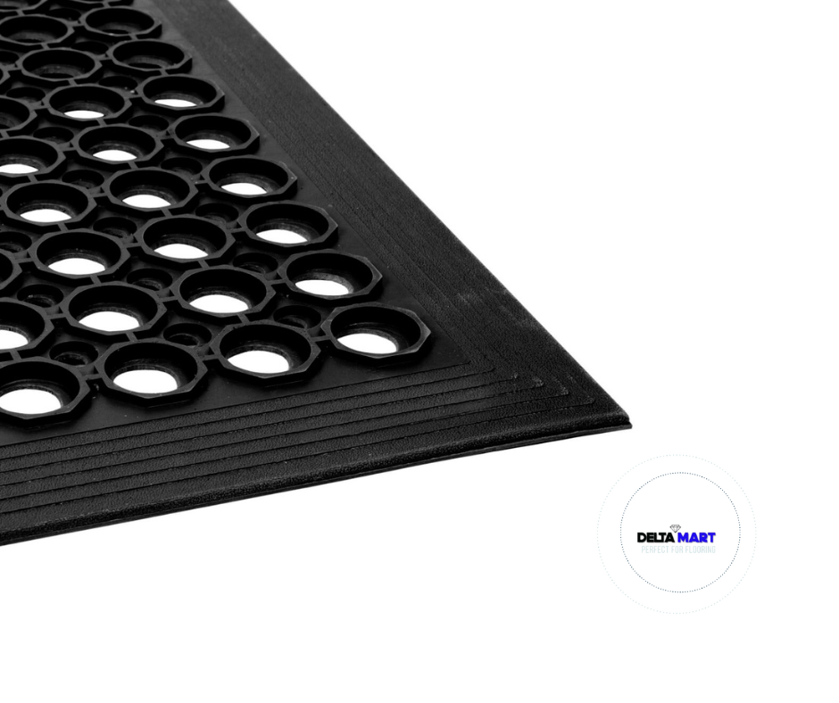 Close-up of a black rubber mat with circular hole pattern and a Delta Mart logo in the corner.