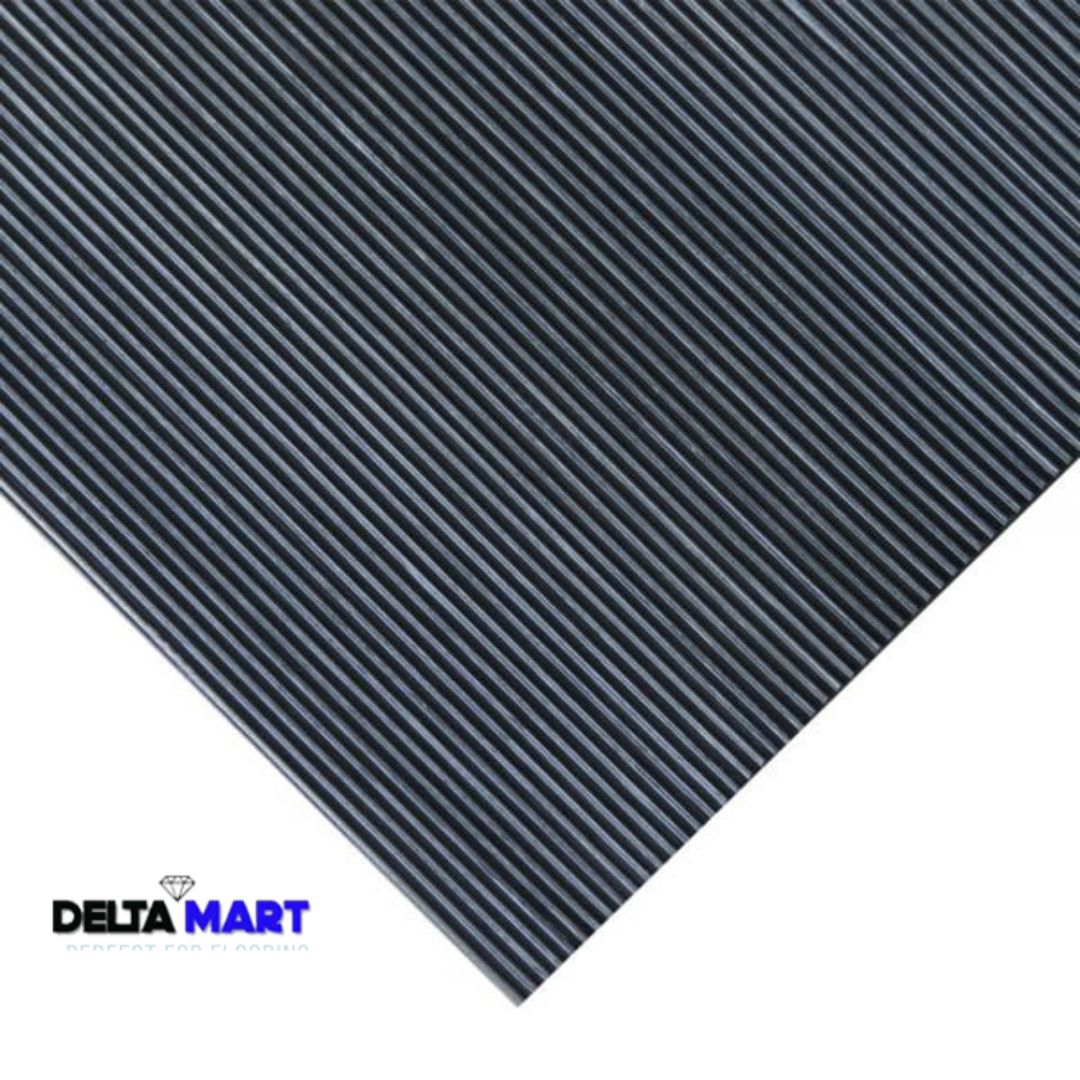 Close-up of a dark grey corrugated metal sheet with diagonal ridges; Delta Mart logo at the bottom-left corner.