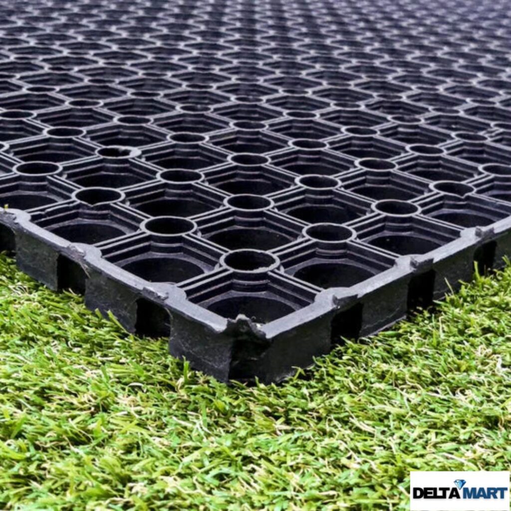 Black rubber grass protection mat laid on a green lawn, an alternative to grass protection mesh