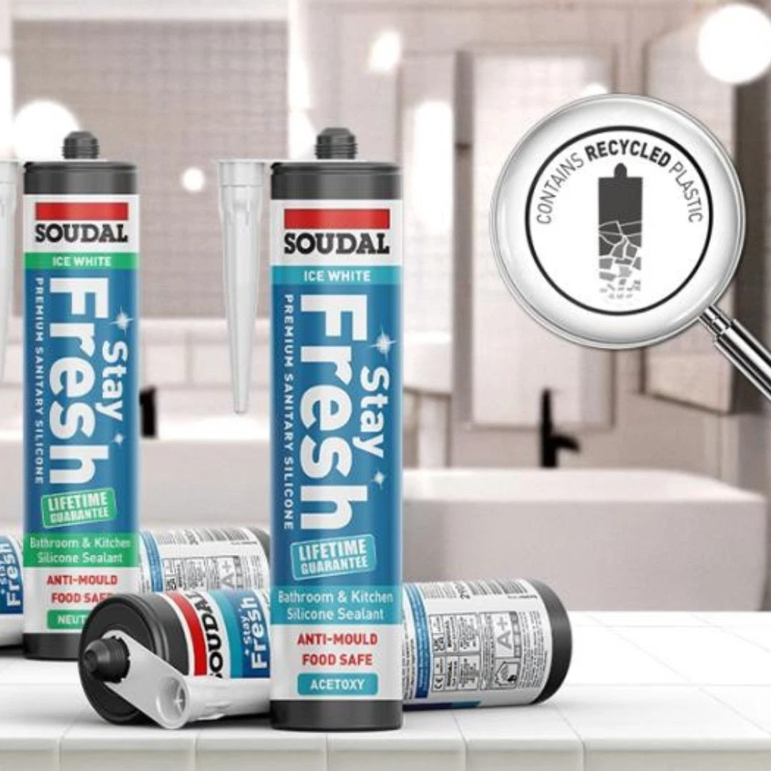 Tubes of Soudal Fresh silicone sealant on a bathroom counter, with a magnifying-glass graphic showing 'contains recycled plastic' in the background.