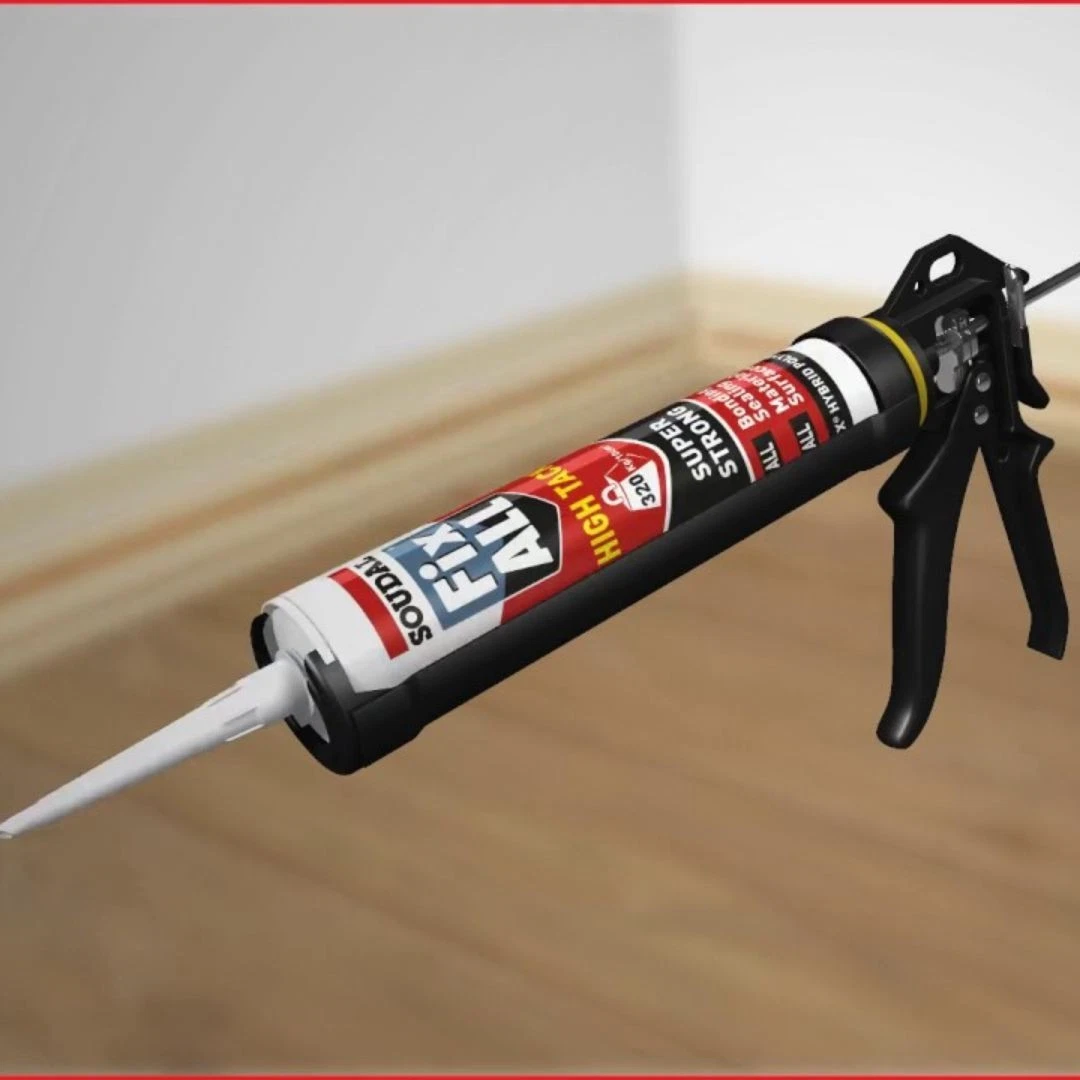 Caulk gun dispensing white sealant from a cartridge onto a floor corner.
